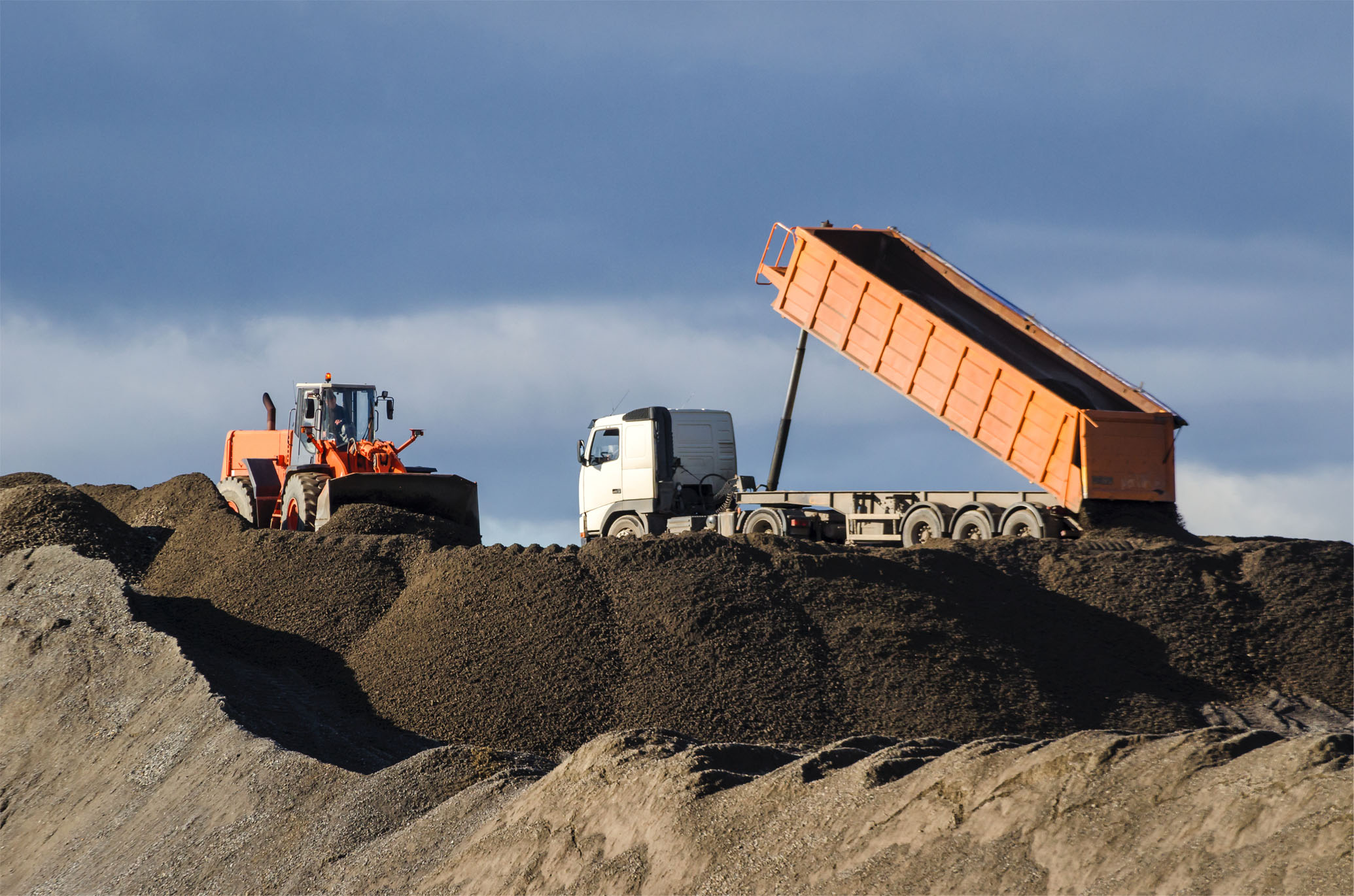 Aggregate delivery of materials with dump truck and tractor